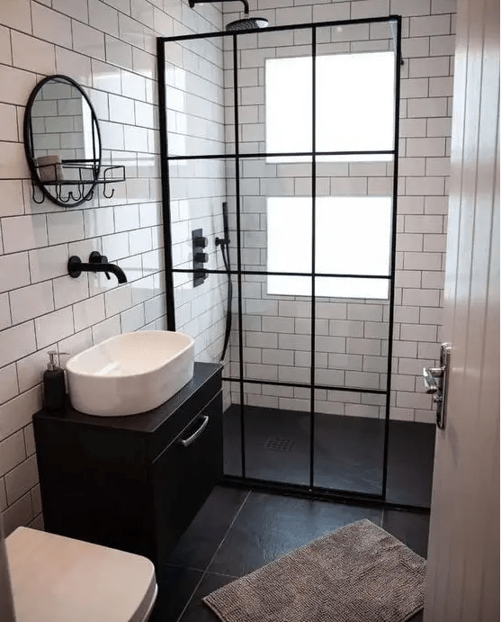 a small, contrasting bathroom with windows in the shower, clad in white and black tiles, a black floating vanity and black accents here and there