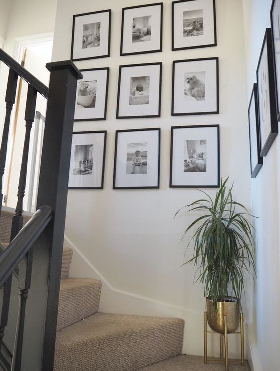 A chic grid gallery wall with matching black frames and black and white photos is a beautiful way to display your family pictures