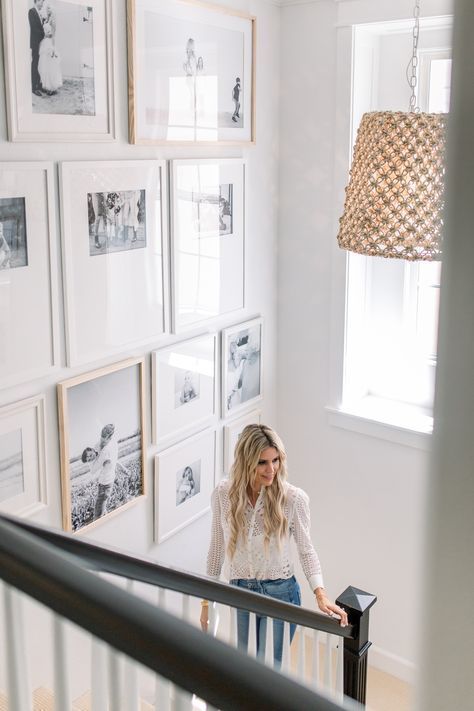 A floor to ceiling gallery wall above the stairs is a cool idea for your space, it looks chic and relaxed and the light frames make it cool and light