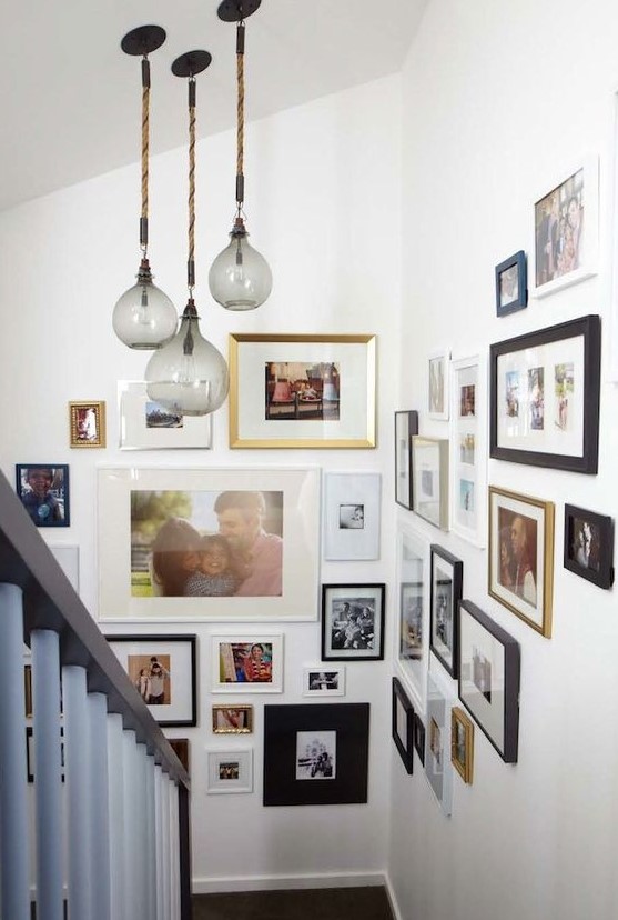A large family gallery wall with mismatched frames and various black and white and color artwork is a cool idea