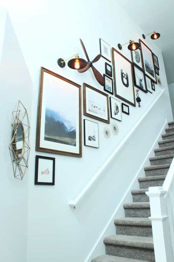 A beautiful gallery wall with beautiful art and photos, mismatched frames, mirrors and chic vintage chandeliers
