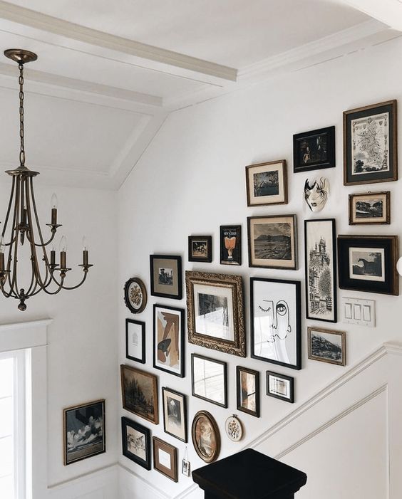 A sophisticated and versatile gallery wall with artwork in various frames, oval, round and others, is a bold addition to the space