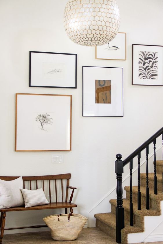 A super chic gallery wall with bold graphics and other artwork and mismatched frames looks ethereal and chic