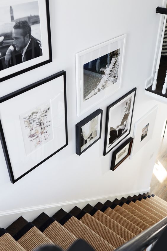 An elegant black and white gallery wall with photos and artwork as well as black and white frames is a beautiful idea for your space