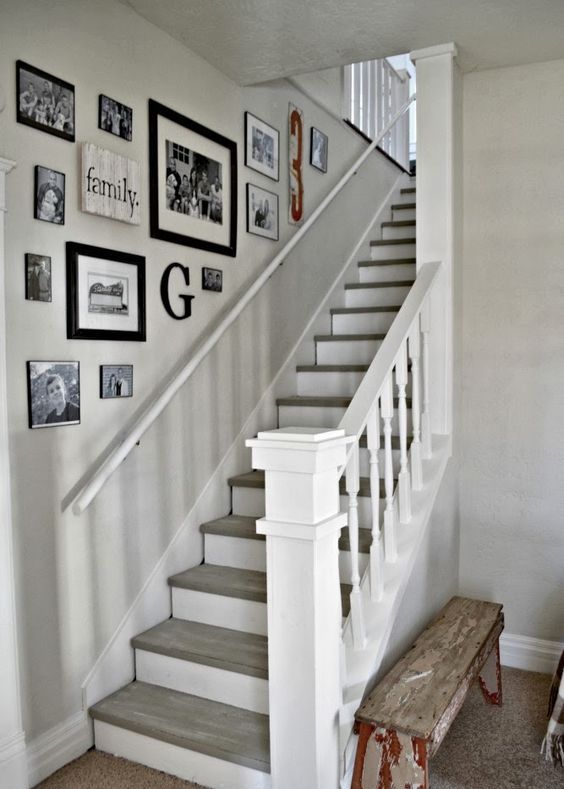 A mismatched black and white gallery wall with family photos, signs and monograms is a cool idea for a rustic space