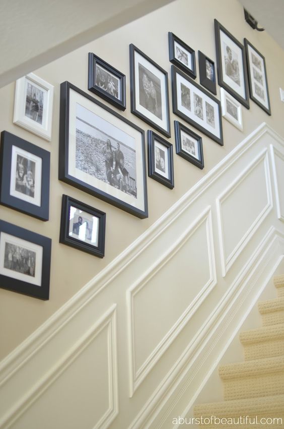 A free-form black and white gallery wall with only family pictures and black and white frames is a chic and stylish solution for a vintage room