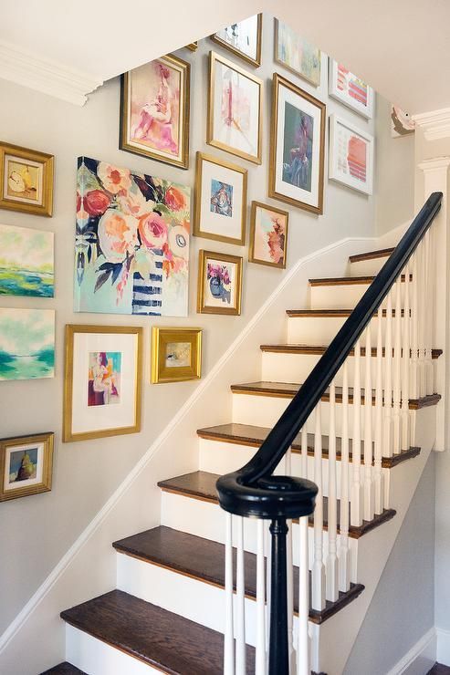 A colorful and fun gallery wall with various bright artwork and gold frames is a great idea for a bold and modern space