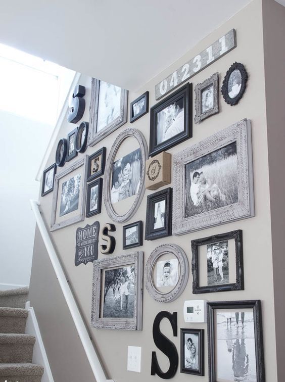 An oversized black and white gallery wall with family photos and mismatched frames that add interest to the room
