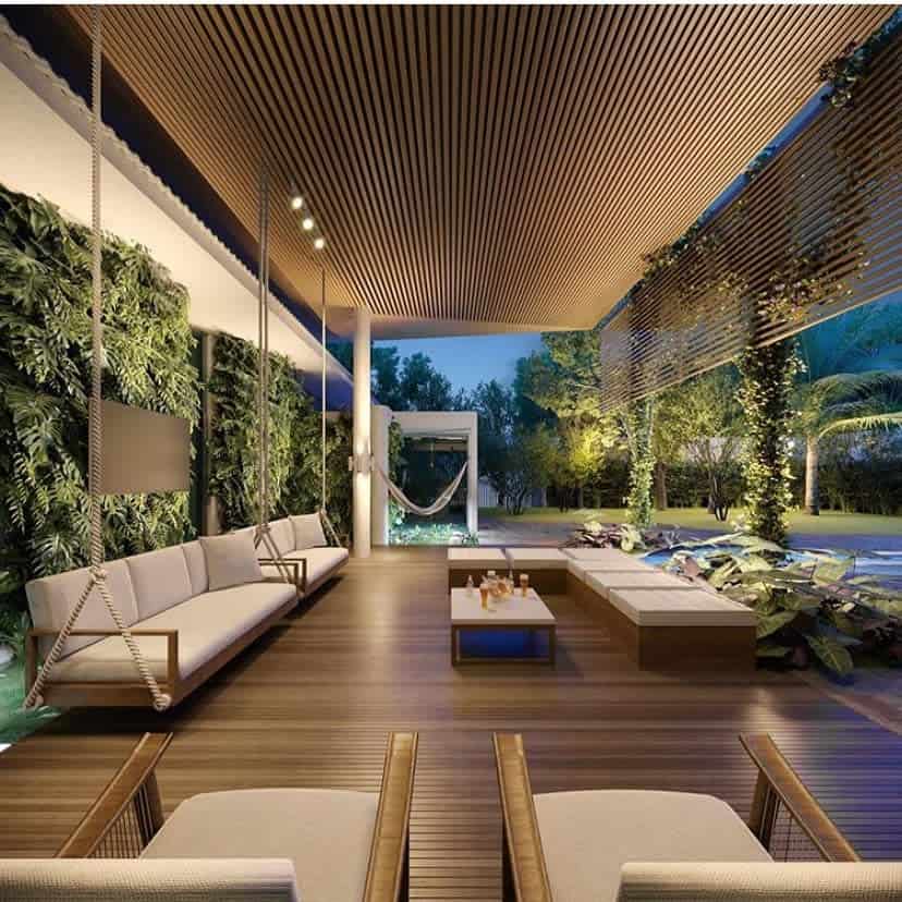 Luxury resort style tan patio hanging seats wall plants