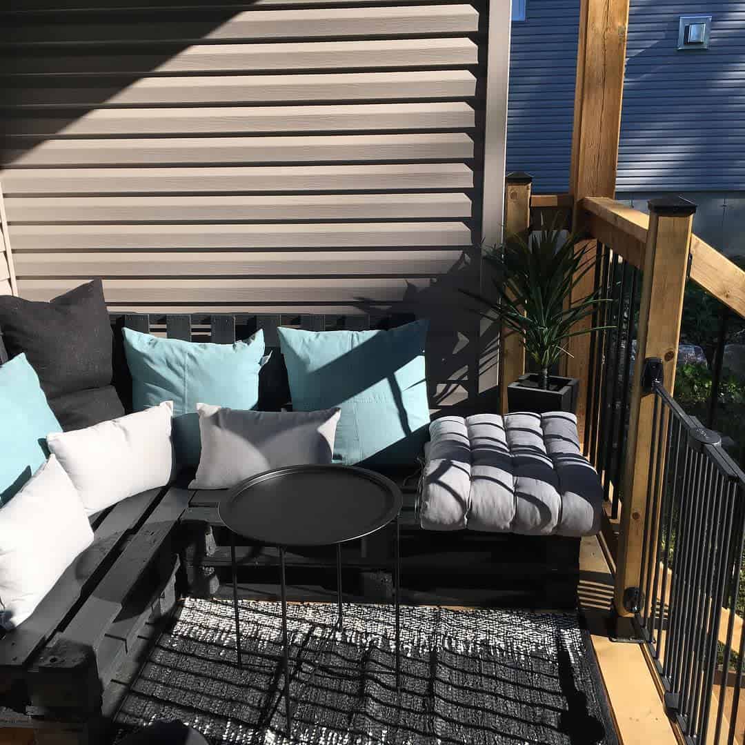 Small wooden deck in the backyard, black railing, painted black box couch