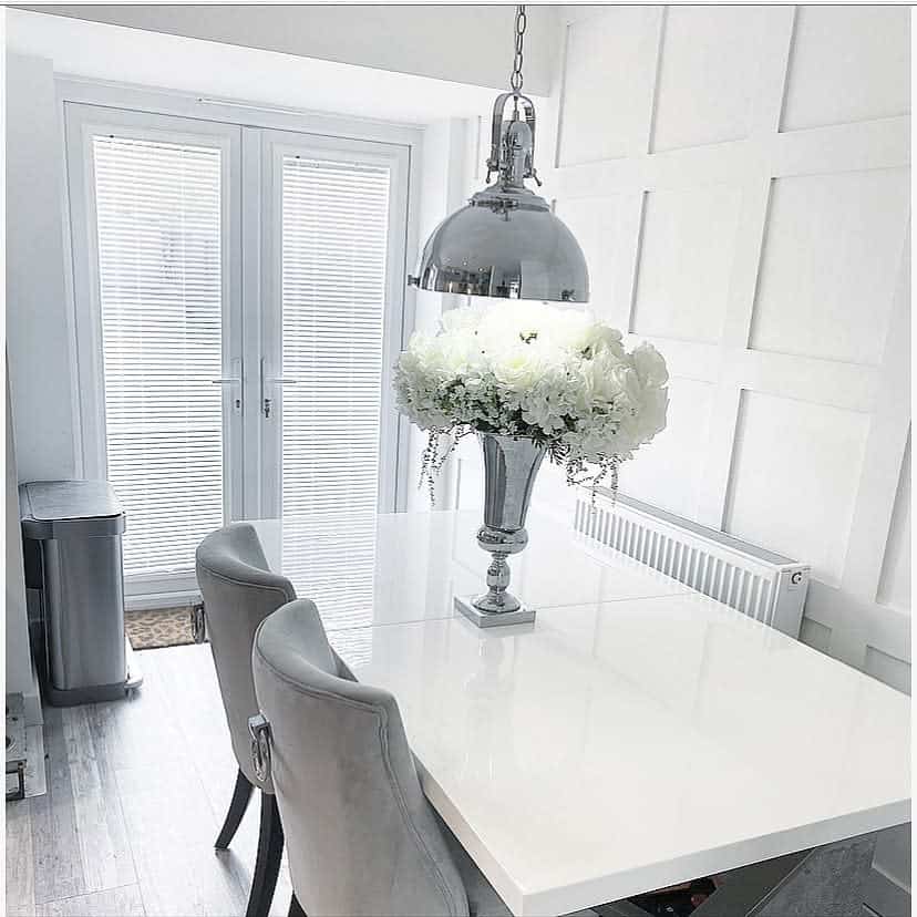 white wall paneling, dining room, silver flower vase, white table 