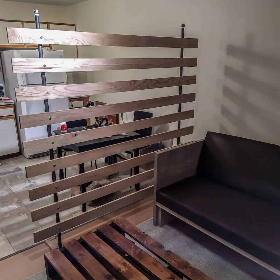 Wall divider made of wooden boards, brown sofa 