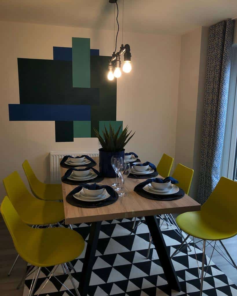 abstract dining room wall art, dining table, yellow chairs, pendant lights 