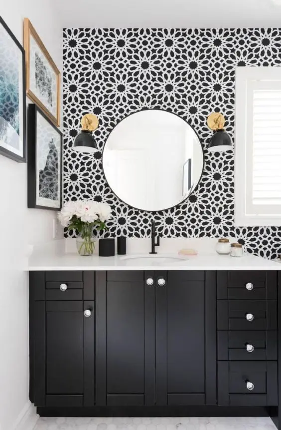 The cool, floral black and white wallpaper makes a stylish statement in the room and catches the eye
