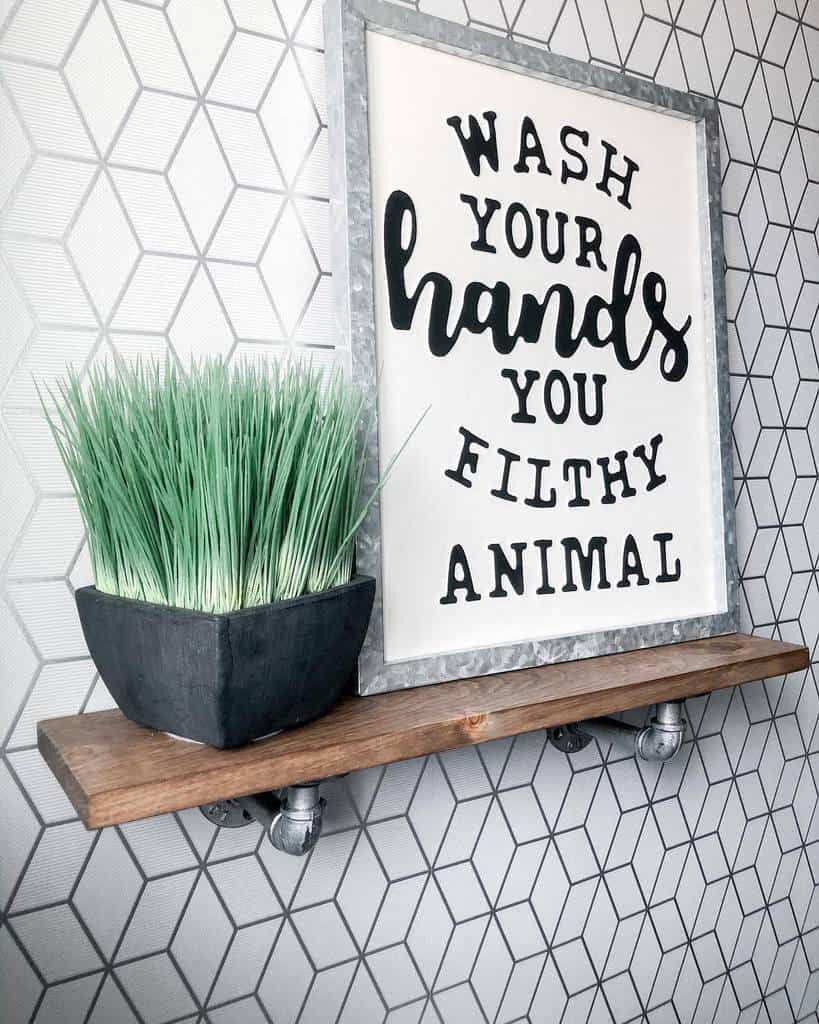 Wooden shelf on patterned tiled wall with plant and slogan artwork