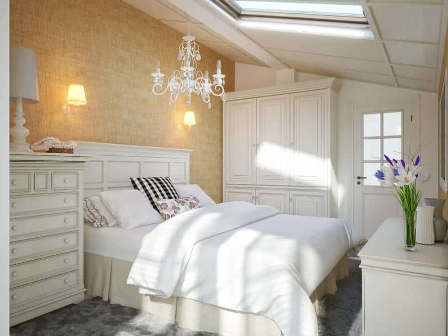 Attic bedroom with wall sconce, white cupboards and wardrobe 