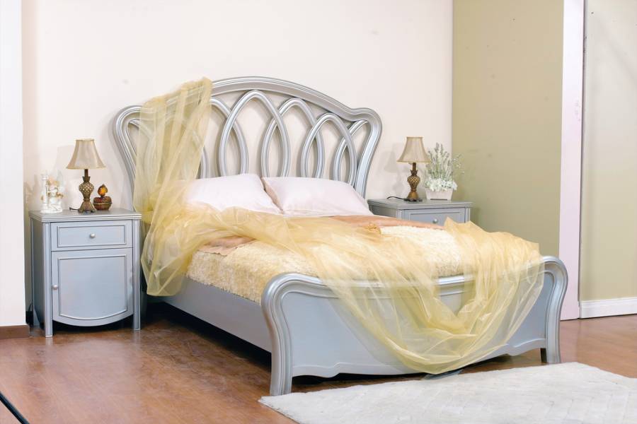 gray bed with elaborate headboard 
