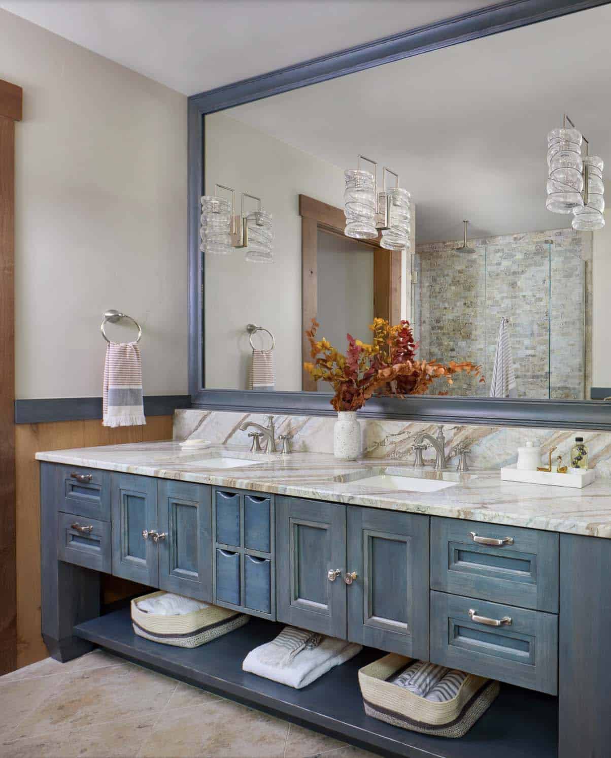 Rustic bathroom with blue cabinets and white marble countertops 