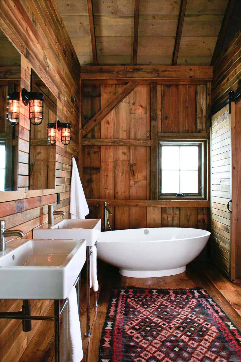 Rustic barn bathroom with freestanding tub and sliding door