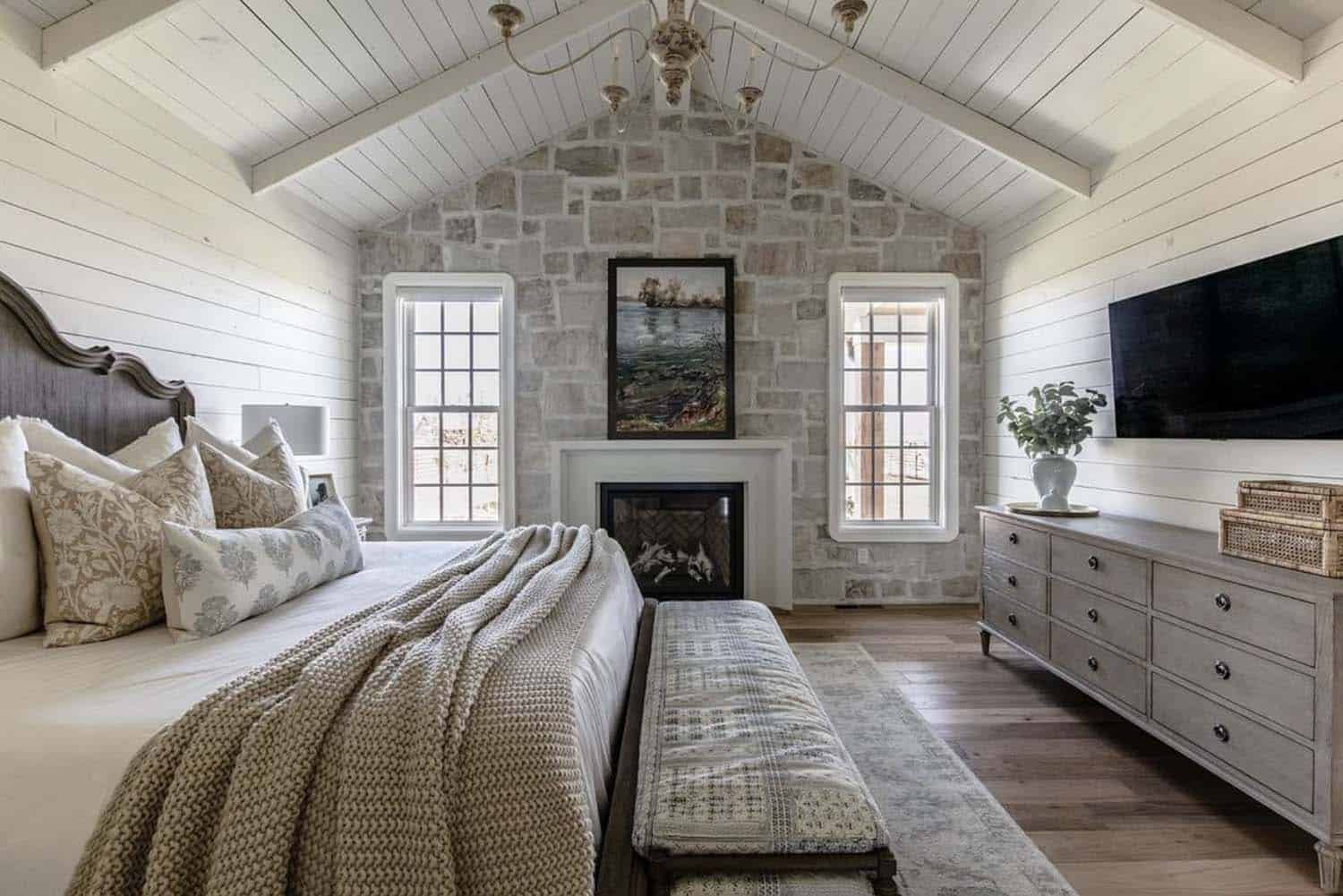 Country house style bedroom with stone wall and fireplace