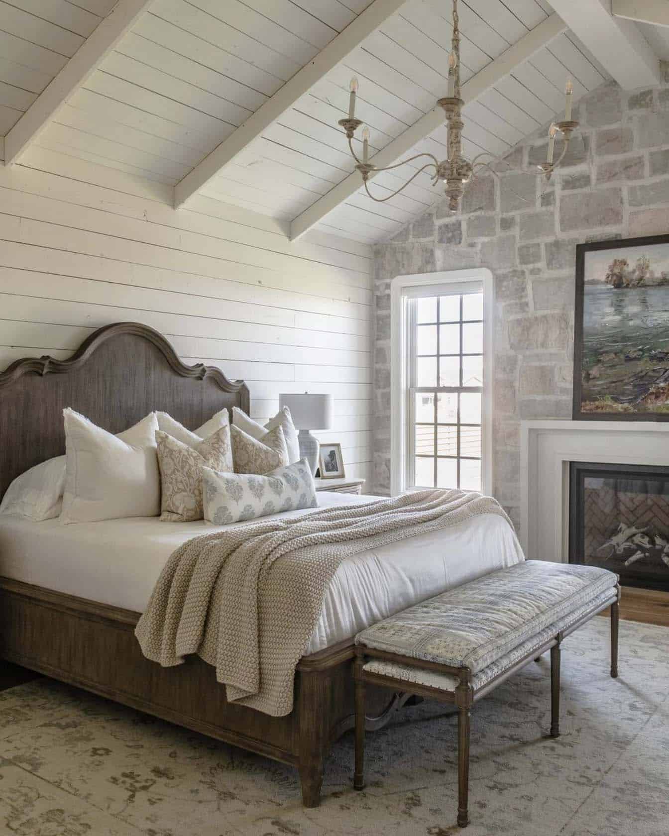 Country house style bedroom with stone wall and fireplace