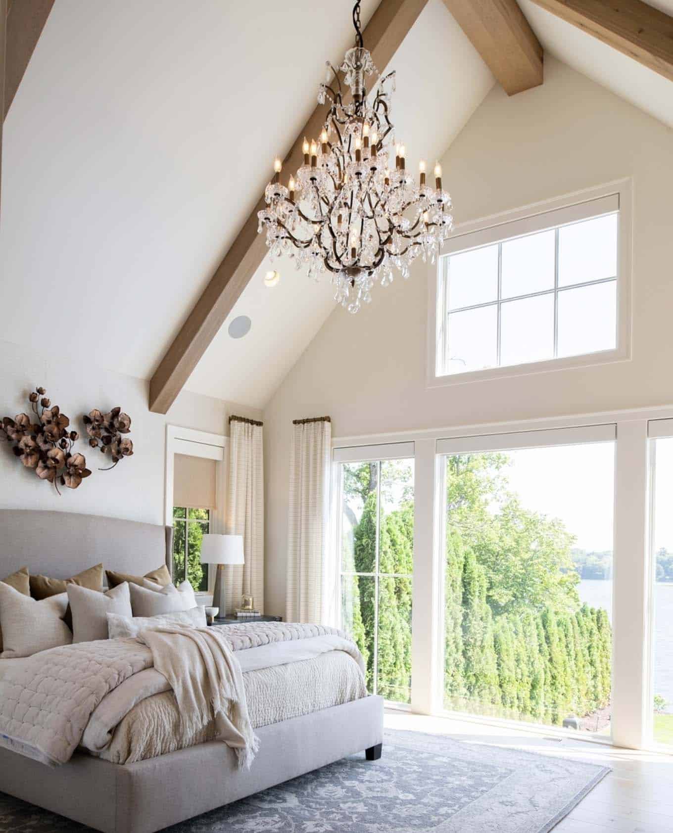 Bedroom with large windows, wooden beams, high ceiling and chandelier