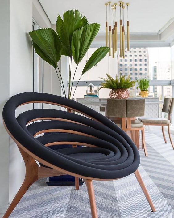 A beautiful black and stained wood chair made up of lots of black upholstered circles is a cool and clever idea