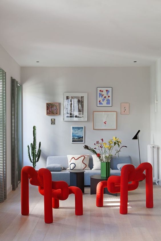 Bold, red-wrapped and curved chairs, each made from a single piece of upholstery, look super cool and accent the room