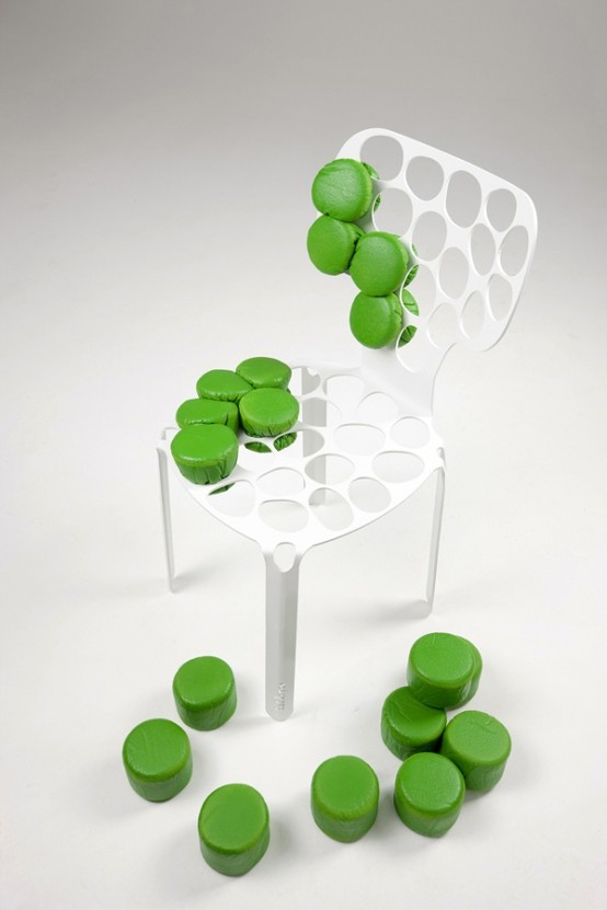 A white metal frame chair with holes and green pouf pieces is a cool solution for any modern and bright room, it looks cool and unusual