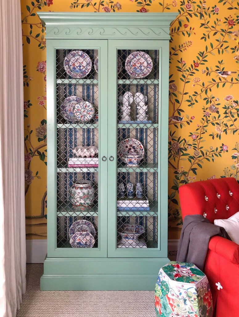 Turquoise bookcase with blue striped wallpaper interior