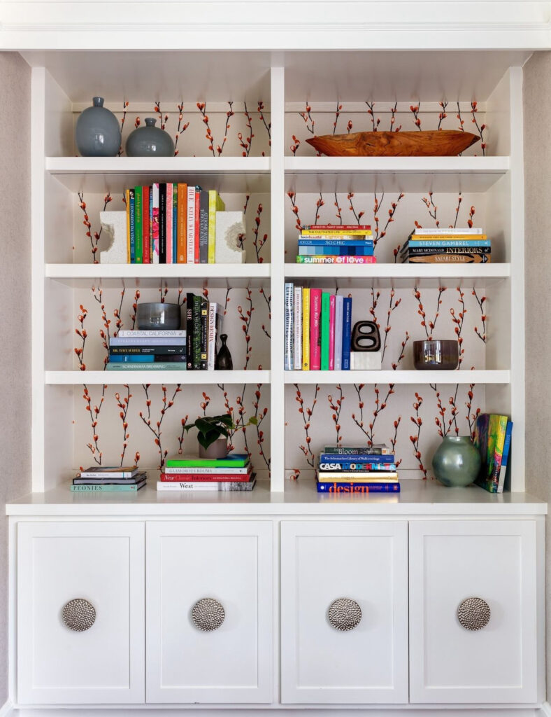 Simple wallpaper with red cherry blossoms on bookshelves with colorful decor