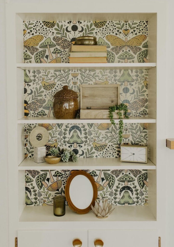 Illustrated wallpaper with enchanted forest on bookshelf with boho decor