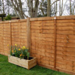 How to put up a garden fence with wooden pos